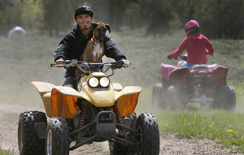Scott Sommerdorf  |  The Salt Lake Tribune
Taylor Lee rides his ATV with his dog Jerzy on board near his family's camp near State Route 150, as 10-year-old Arianne Anderson rides by at right. The Mirror Lake Highway is now open just in time for the Memorial Day Weekend, Sunday, May 26, 2013.