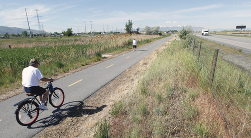 Al Hartmann  |  The Salt Lake Tribune
A bicycle rider and walker take some excercise along the Legacy Highway's multi use Bicycle/Pedestrian/Equestrian Trail near the Pages Lane Trailhead Tuesday May 21. Legacy Highway is on  the right. Dozens of lead and arsenic samples along rails-to-trails routes, including the Denver & Rio Grande Trailhead along the Great Salt Lake and the Historic Union Pacific Trail in Park City, are up to 15 times higher than safe levels.