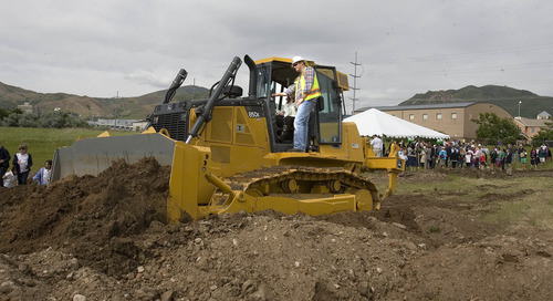 Paul Fraughton  |  The Salt Lake Tribune
With Ted Siri of Reynolds Excavation standing nearby, Rin Harris plows up the first patch of land at the ground breaking for the expansion of the Rowland Hall campus on Sunnyside Avenue. Rin, who has two children attending the school, won the honor of driving the John Deere Dozer at a fundraising auction.                         
 Wednesday, May 29, 2013
