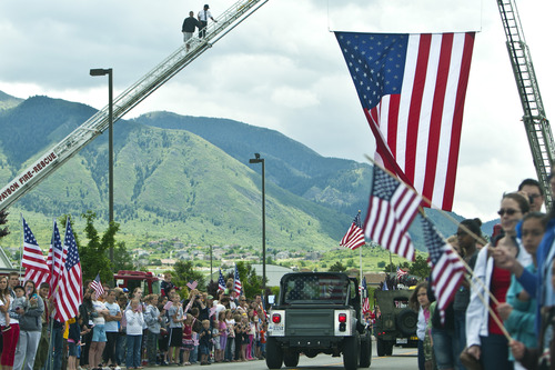 Chris Detrick  |  The Salt Lake Tribune
Friends and community members watch as the body of Elk Ridge Army medic Cody Towse is driven to his home along Elk Ridge Drive Wednesday May 29, 2013. Towse, 21, died May 14 near Sanjaray, Afghanistan, when an improvised explosive device (IED) detonated as he rushed to provide medical care to a wounded soldier. He was one of four soldiers on foot patrol who died in a series of four IED blasts that day, including two men assigned with Towse to the 3rd Battalion, 41st Infantry Regiment, 1st Brigade Combat Team, 1st Armored Division from Fort Bliss, Texas.
