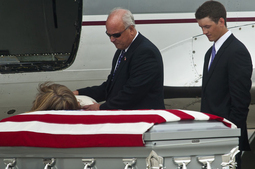 Chris Detrick  |  The Salt Lake Tribune
Jamie Towse rests her cheek on Elk Ridge Army medic Cody Towse's flag-draped casket as she is consoled by her husband Jim at the Provo Municipal Airport Wednesday May 29, 2013. At right is brother Will Towse, 20. Towse, 21, died May 14 near Sanjaray, Afghanistan, when an improvised explosive device (IED) detonated as he rushed to provide medical care to a wounded soldier. He was one of four soldiers on foot patrol who died in a series of four IED blasts that day, including two men assigned with Towse to the 3rd Battalion, 41st Infantry Regiment, 1st Brigade Combat Team, 1st Armored Division from Fort Bliss, Texas.