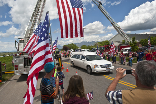 Chris Detrick  |  The Salt Lake Tribune
Friends and community members watch and take pictures as the body of Elk Ridge Army medic Cody Towse is driven to his home along Elk Ridge Drive Wednesday May 29, 2013. Towse, 21, died May 14 near Sanjaray, Afghanistan, when an improvised explosive device (IED) detonated as he rushed to provide medical care to a wounded soldier. He was one of four soldiers on foot patrol who died in a series of four IED blasts that day, including two men assigned with Towse to the 3rd Battalion, 41st Infantry Regiment, 1st Brigade Combat Team, 1st Armored Division from Fort Bliss, Texas.