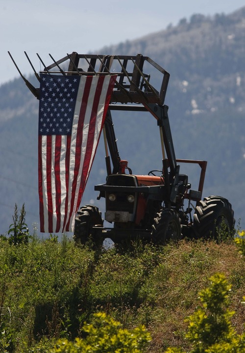 Leah Hogsten  |  The Salt Lake Tribune
An American flag hangs from a tractor on a hill overlooking the Salem City Cemetery in the small farming town. Funeral services for Army medic Cody Towse, who was killed by an improvised explosive device in Afghanistan last week, were held at Salem Hills High School in Salem, Utah, Saturday, June 1, 2013.