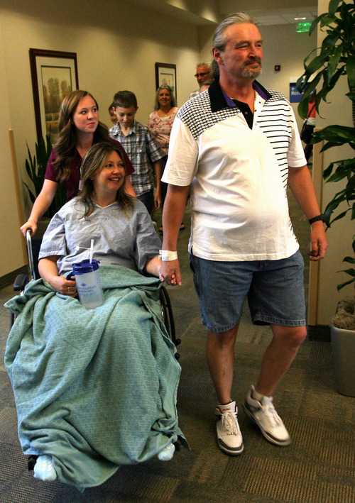 Rick Egan  | The Salt Lake Tribune 

Lynnete holds hands with her husband Jeffery, as she is wheeled down the hall at Intermountain Medical Center to talk to the media about the birth of her twins on I-80 yesterday morning. Monday, June 3, 2013.