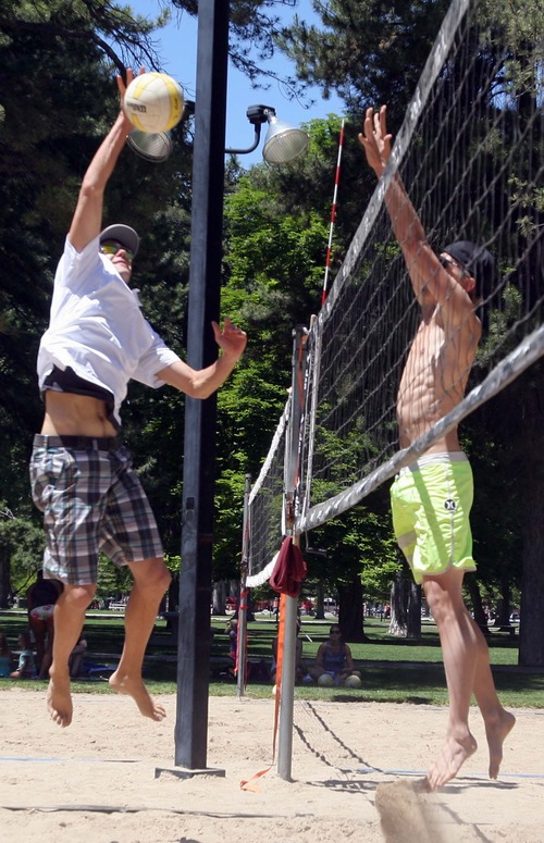 Rick Egan  | The Salt Lake Tribune 

Jake Gibb  (left) goes up against Joe Nelson, at Liberty Park, Wednesday, June 5, 2013. Gibb is promoting the AVP Pro Beach Volleyball Tour coming to Utah in August.