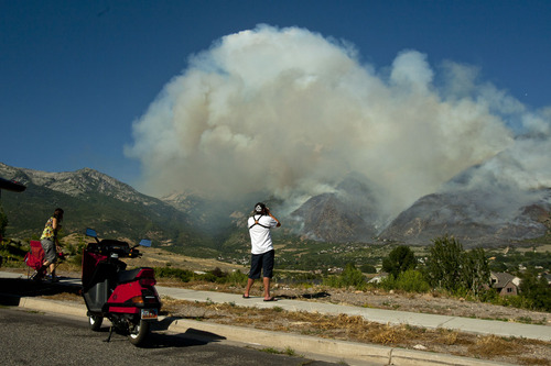 Chris Detrick  |  Tribune file photo
Residents watch as the Quail Fire burns above Alpine on July 3, 2013. Authorities have determined a track hoe sparked the fire, which cost about $1.3 million to suppress, but declined to prosecute those responsible.