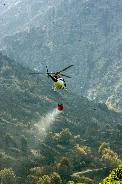 Paul Fraughton |  The Salt Lake Tribune
A helicopter takes its load of water high up to remote areas where the Quail Fire was burning in July 2012. Authorities have determined a track hoe sparked the fire, which cost about $1.3 million to suppress, but declined to prosecute those responsible.
