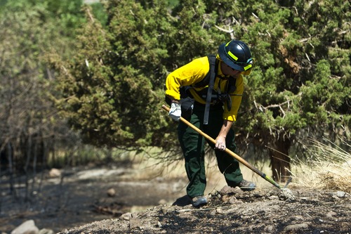 Chris Detrick  |  The Salt Lake Tribune
A member of the Goshen Fire department helps put out hot spots in the Rose Crest Fire in Herriman Saturday June 30, 2012.