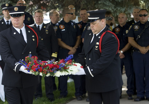 Kim Raff  |  The Salt Lake Tribune
Salt Lake City Fire Department Honor Guard members (right) Myke (cq) Workman and (left) Daren Mortenson carry a wreath memorial during service for Salt Lake City firefighter Lt. Paul Hamilton who was fatally injured 70 years ago while battling a hotel fire on a 100-foot ladder when the ladder collapsed at this spot on 400 South Main Street in Salt Lake City on June 10, 2013.