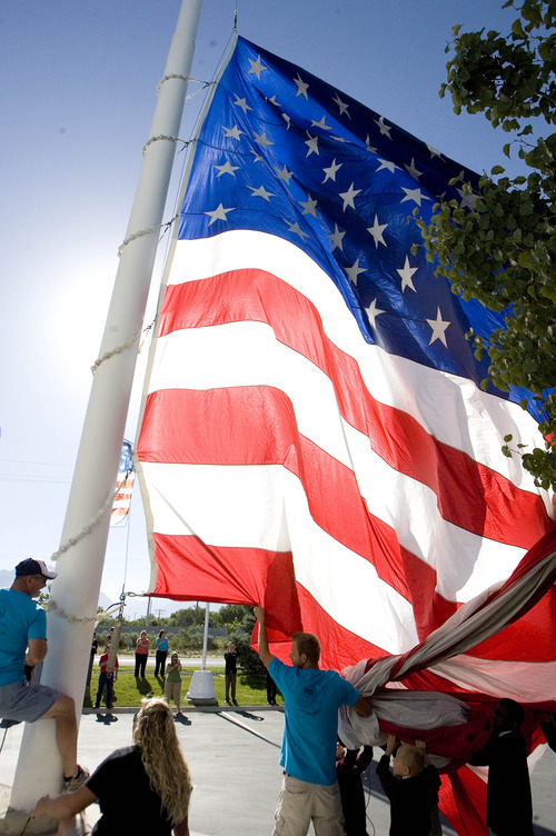 Paul Fraughton  |  The Salt Lake Tribune
To commemorate Flag Day, Colonial Flag in Sandy raised its 30-by-60 American flag after a brief ceremony. The Challenger School's corporate headquarters, across the street from Colonial, raised an identical flag at the same time.