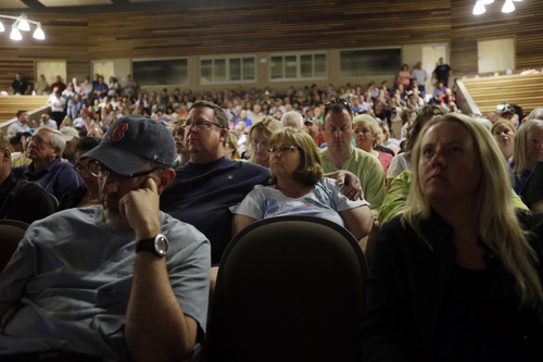 Black Forest, Colo., resident Carol Sisk, center, is embraced by her husband Marc during an informational meeting on the progress of the Black Forest Fire at Palmer Ridge High School in Monument, Colo. on Saturday, June 15, 2013. (AP Photo/Marcio Jose Sanchez)