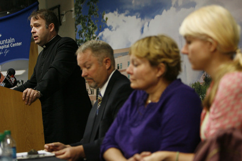 Francisco Kjolseth  |  The Salt Lake Tribune
Family spokesperson, Father Eric Richtsteig, left, talks about the violent events that happened during Mass on Sunday morning where James Evans was shot in the head. Also pictured are Chris Dallin, spokesperson for McKay-Dee Hospital and Tara and Karen Evans, wife and daughter of James Evans who is recovering from his wound at the hospital.