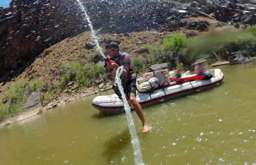 Francisco Kjolseth  |  The Salt Lake Tribune
River guide Justin Malloy abandonds ship as he attempts a jumping attack on another boat only to be pummeled in return while floating the Colorado in July of 2012.