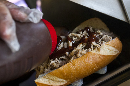 Chris Detrick  |  The Salt Lake Tribune
Tommy T. Brown makes a pulled pork sandwich in his Q4U barbecue truck Wednesday June 5, 2013.