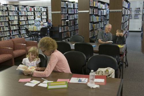 Paul Fraughton  |  The Salt Lake Tribune
Sandra Ozosky, front right, helps Julia Trotter, 7, with her reading. In the rear Bill Lithgow helps Eathen Kranendonk, 8, with his reading skills. The adults are volunteers participating in a program at the Weber County Library to tutor youngsters who need help with reading skills.