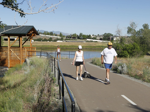 Al Hartmann  |  The Salt Lake Tribune
Walkers take morning excercise along Big Cottonwood Trail's last segment paralleling a stretch of Big Cottonwood Creek in Old Mill Park Monday June 17. Roughly 1.5 miles long from end to end, the full trail is a 10-foot-wide asphalt path that begins at I-215 near the Cottonwood Corporate Center and gradually rises toward the canyon, crossing 3000 East, jogging past a small reservoir and paralleling a stretch of Big Cottonwood Creek in Old Mill Park and ends at the park-and-ride lot inside Big Cottonwood Canyon.