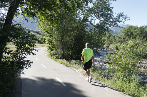 Al Hartmann  |  The Salt Lake Tribune
A walker takes in morning excercise along Big Cottonwood Trail's last segment paralleling a stretch of Big Cottonwood Creek in Old Mill Park Monday June 17. Roughly 1.5 miles long from end to end, the full trail is a 10-foot-wide asphalt path that begins at I-215 near the Cottonwood Corporate Center and gradually rises toward the canyon, crossing 3000 East, jogging past a small reservoir and paralleling a stretch of Big Cottonwood Creek in Old Mill Park and ends at the park-and-ride lot inside Big Cottonwood Canyon.