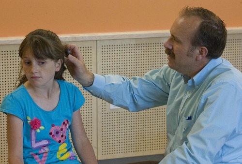 Paul Fraughton  |   Salt Lake Tribune
Cache Pitt, a doctor of audiology at Utah State University, helps  11-year-old Emily Heaps with an upgrade to her cochlear implant. Hearing loss is one of the few residual signs of her battle with severe combined immunodeficiency syndrome (SCID), also known as "boy in the bubble" disease. Monday, June 17, 2013