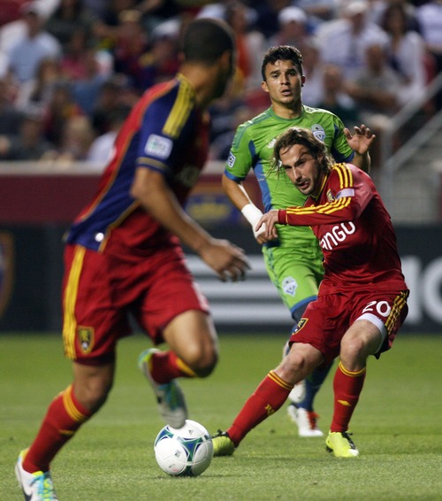 Kim Raff  |  The Salt Lake Tribune
(right) Real Salt Lake midfielder Ned Grabavoy (20) passes the ball to (left) Real Salt Lake forward Alvaro Saborio (15) as (back) Seattle Sounders FC midfielder Servando Carrasco (23) looks on during the second half at Rio Tinto Stadium in Sandy on June 22, 2013. Real went on to win the game 2-0.