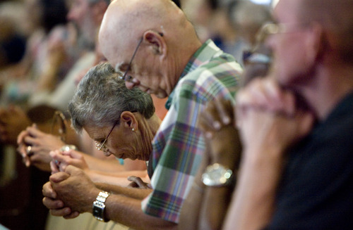 Kim Raff  |  The Salt Lake Tribune
Alice Weil, left, prays at St. James the Just Catholic Church in Ogden during a Mass of Reparation ceremony on Thursday. The ceremony was scheduled to cleanse the church after James Evans was allegedly shot by his son-in-law Charles Richard Jennings Jr. during a church service last Sunday.