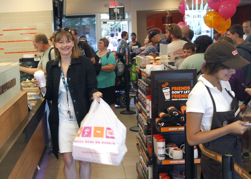 Al Hartmann  |  The Salt Lake Tribune
Happy customer leaves the counter with coffee and a big bag of doughnuts at the grand opening of Dunkin' Donuts at 217 E. 400 South on Tuesday, June 25. The Utah franchise, Sizzling Platter, is planning to open up to 23 Dunkin' Donuts outlets along the Wasatch Front and northern Utah during the next five years.