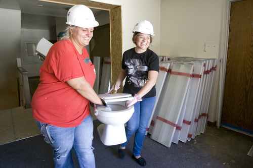 Rick Egan  | The Salt Lake Tribune 

Steephanie Soules and Allie Roberts, volunteers from OC Tanner, are remove a toilet from the old LDS church on 400 East and 100 South in Salt Lake, Wednesday, June 26, 2013. The American Cancer Society has donated a retired LDS Church building to Habitat for Humanity, which will eventually be a Hope Lodge for cancer patients.
