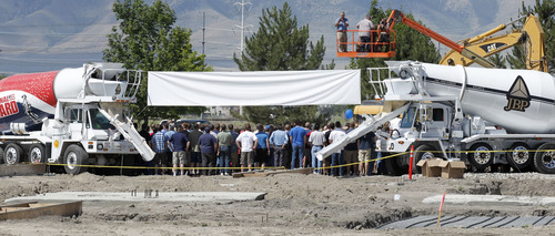 Al Hartmann  |  The Salt Lake Tribune
Employees of the dental software and services division of Henry Schein stand between cement mixers for a group photo on the site of the new 100,000-square-foot facility to be built in North Pointe Business Park in American Fork.     Henry Schein is the world's largest provider of health care products and services to office-based dental, medical, and animal health practitioners.  Also, the facility will include a full dental clinic where dentists will provide "pro bono" care to the needy.