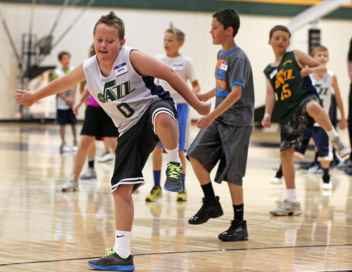 Michael Brandy  |  Special to the Tribune
Benton Bair (11yrs) and other Junior Jazz kids from Farmington, Utah go through drills during  a basketball clinic by the Utah Jazz draft picks (Trey Burke, Rudy Gobert and Raul Neto) at Zions Bank Basketball Center.