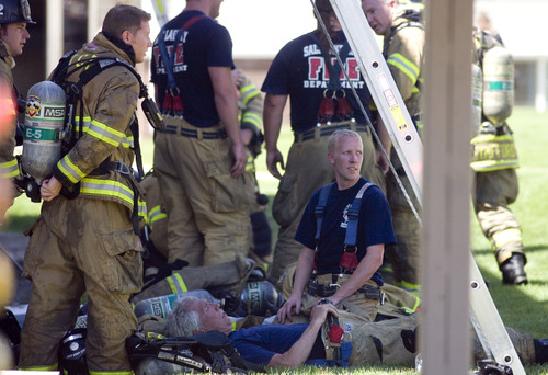 Kim Raff  |  The Salt Lake Tribune
As temperatures climb above 100 degrees, Salt Lake City firefighters cool down in the shade while working to put out a fire at the Park City Apartments off of 900 West in Salt Lake City on June 30, 2013.