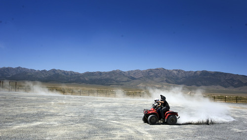 Rick Egan  | The Salt Lake Tribune 

Christan Anderson, 13, and Tristan Thompson, 14, stir up dust as they cruise around on an ATV in a vacant lot in Grantsville, Monday, July 1, 2013.