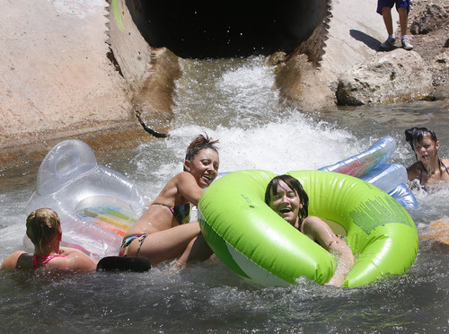 Scott Sommerdorf   |  The Salt Lake Tribune
Girls "shoot the tube" and tumble into the pool at the end of a culvert that empties into Parleys Creek in Tanner Park, Sunday, June 30, 2013.