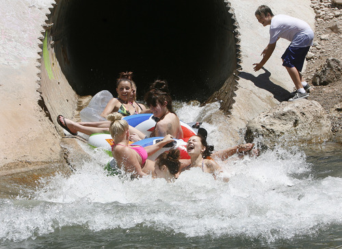 Scott Sommerdorf   |  The Salt Lake Tribune
Girls "shoot the tube" as they cool off in the pool that empties into Parleys Creek in Tanner Park, Sunday, June 30, 2013.