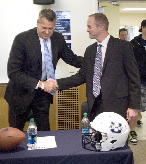 Paul Fraughton  |   The Salt Lake Tribune
Scott Barnes, Utah State Director of Athletics, shakes hands with Matt Wells at a press conference Thursday where Wells was named the 27th head coach of the Aggie football program.