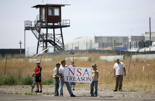 Francisco Kjolseth  |  The Salt Lake Tribune
Opponents of the NSA Data Center, in background, protest the center on the 4th of July, following a march up to the access road to the facility along Redwood Road across from Camp Williams.