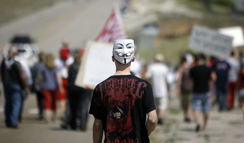 Francisco Kjolseth  |  The Salt Lake Tribune
Opponents of the NSA Data Center protest the center on the 4th of July, following a march up to the access road to the facility along Redwood Road across from Camp Williams.