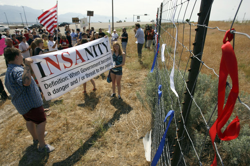 Francisco Kjolseth  |  The Salt Lake Tribune
Red, white and blue ribbons are tied to the outer perimeter fence of the new NSA Data Center as opponents of the facility protest on the 4th of July.