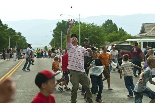 Chris Detrick  |  The Salt Lake Tribune
Children and adults look to catch ping pong balls as they are dropped from an airplane during the 4th of July parade in Moroni Thursday July 4, 2013.