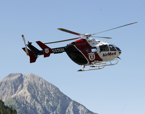 Al Hartmann  |  The Salt Lake Tribune
AirMed helicopter touches down at Tibble Fork Reservoir parking lot in American Fork Canyon Monday July 8 to pick up search and rescue personnel to help in the recovery of two injured men whose helicopter crashed and rolled after hitting a hill high up in the mountains near the Utah-Salt Lake County line.  They were able to extricate themselves from the wreck and use a cell phone to call for help about 8:30 a.m.