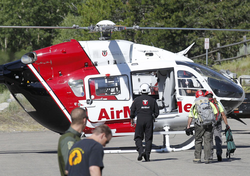 Al Hartmann  |  The Salt Lake Tribune
Utah county Search and Rescue members climb aboard AirMed helicopter at Tibble Fork Reservoir parking lot in American Fork Canyon Monday July 8 to help in the recovery of two injured men whose helicopter crashed and rolled after hitting a hill high up in the mountains near the Utah-Salt Lake County line.  They were able to extricate themselves from the wreck and use a cell phone to call for help about 8:30 a.m.