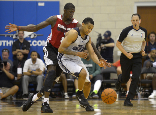 Utah Jazz guard Trey Burke, center, gains control of a loose ball in front of Miami Heat guard forward James Ennis, left, during the second half of an NBA Orlando Pro Summer League game in Orlando, Fla., Sunday, July 7, 2013. (Special to the Tribune/Phelan M. Ebenhack)