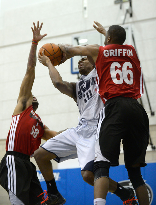 Utah Jazz guard Alec Burks (10) goes up for a shot between Miami Heat guard D.J. Kennedy, left, and Eric Griffin (66) during the first half of an NBA Orlando Pro Summer League game in Orlando, Fla., Sunday, July 7, 2013. (Special to the Tribune/Phelan M. Ebenhack)