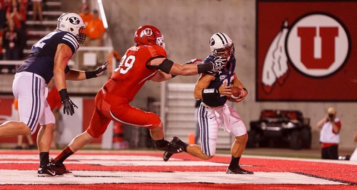 Trent Nelson  |  The Salt Lake Tribune
Utah defensive end Joe Kruger (99) brings down Brigham Young quarterback Riley Nelson (13) for what would have been a safety but a face mask penalty was called during the game in Salt Lake City on Saturday, Sept. 15, 2012.