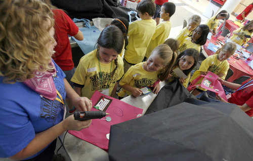 Francisco Kjolseth  |  The Salt Lake Tribune
Kids line up behind Michelle McKee as the crafts co-leader helps assemble kids Western themed bags during Vacation Bible School for St. John the Baptist Catholic Church. The week long camp held at Juan Diego Catholic high school ties teachings from the bible with fun activities for kids.