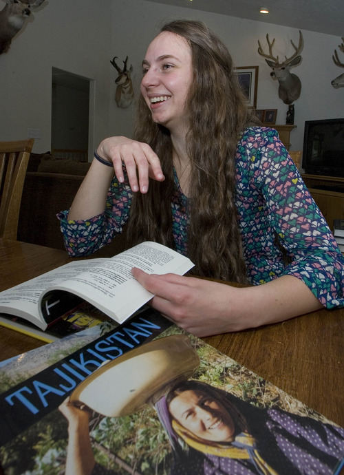 Paul Fraughton  |   Salt Lake Tribune
   Ashlin Gates sits at the dining room table of her family's Riverton home looking through books on Tajikistan, the country she will be visiting this summer  as part of a state department program.                         
 Thursday, May 30, 2013