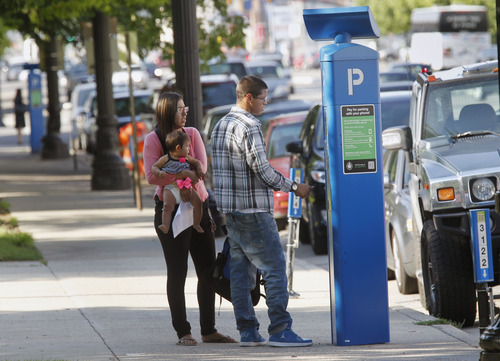 Al Hartmann  |  The Salt Lake Tribune
Couple tries to pay for parking at pay station on State Street in Salt Lake City Tuesday July 9 despite the message that says "free parking."  The machines can be confusing to new users.   Salt Lake City's new, high-tech parking meters have been  offline for several days due to extreme heat.  The city has lost about $90,000.  They are planned to go online again Wednesday.
