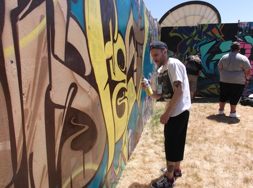 Artist Pablo Pinet works on the interactive graffiti wall in the Urban Arts area at the Utah Arts Festival on Thursday. (photo by Sean P. Means  |  The Salt Lake Tribune)