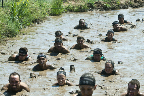 Chris Detrick  |  The Salt Lake Tribune
Competitors crawl and swim through a mud pit during the Utah Spartan Beast Race at Soldier Hollow Saturday June 29, 2013. The 12-mile race included obstacles like mud pits with barbed wire, rope climbs, jumping over fire and climbing an eight-foot wall.