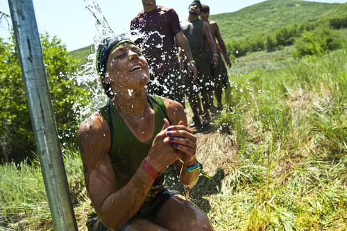 Chris Detrick  |  The Salt Lake Tribune
Competitors wash off with water after swimming through a mud pit three-quarters of the way through the Utah Spartan Beast Race at Soldier Hollow Saturday June 29, 2013. The 12-mile race included obstacles like mud pits with barbed wire, rope climbs, jumping over fire and climbing an eight-foot wall.