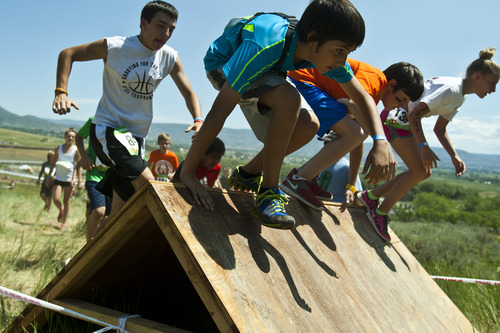 Chris Detrick  |  The Salt Lake Tribune
Kids jump over an obstacle during the Spartan Kids Race at Soldier Hollow Saturday June 29, 2013.