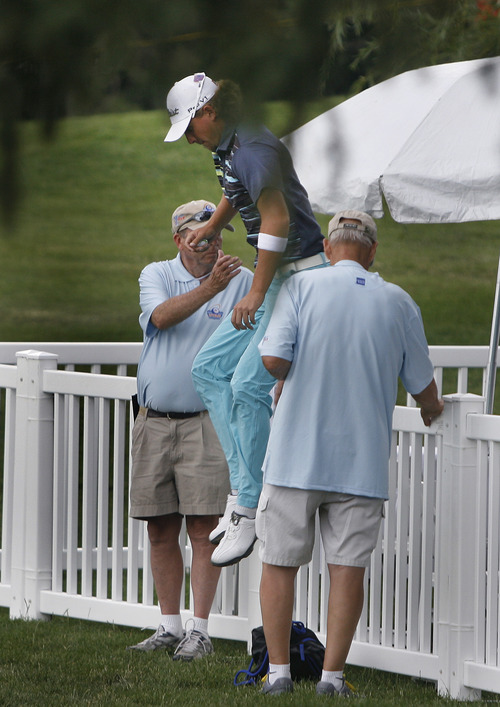 Scott Sommerdorf   |  The Salt Lake Tribune
After retrieving his ball from inside a spectators seating area near the 18th green, Canadian player Roger Sloan jumps back over the fence on the par 3 finishing hole at Willow Creek Country Club, Thursday, July 11, 2013. Sloan took a drop and finished the hole with a bogey to leave him at 65 for the day.